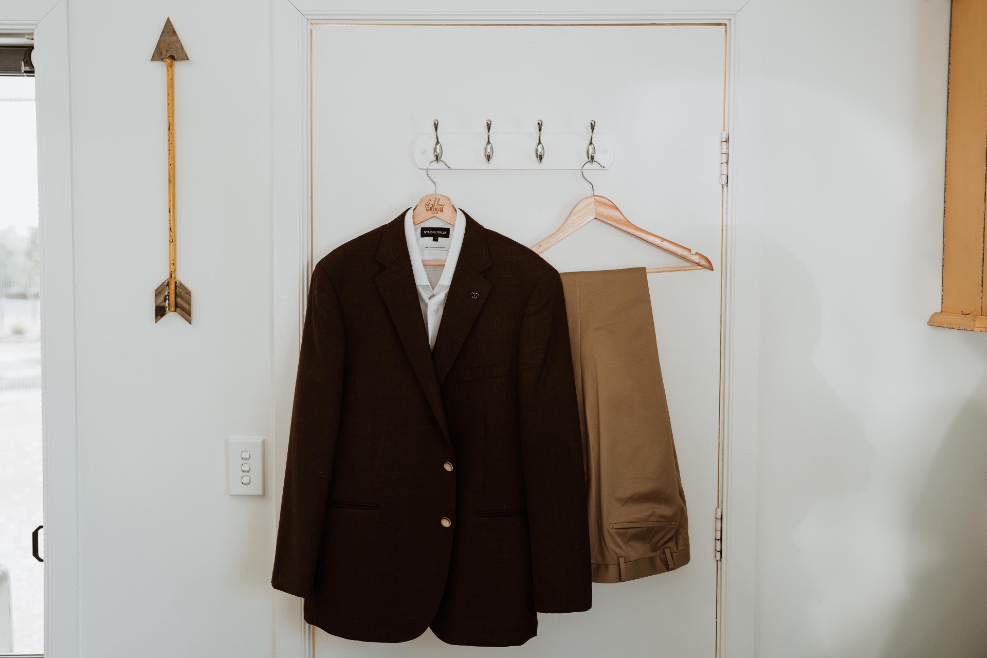 Brown blazer, white dress shirt and tan trousers hanging together before the ceremony — groom suit alterations and tailoring by Jacqui, NSW South Coast