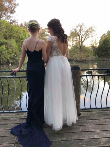 Formal black satin gown fitted for a wedding guest standing beside the bride by a pond — formal gown alterations and fitting by Jacqui, NSW South Coast